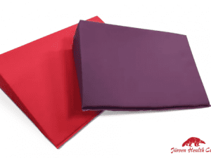 Ein rotes und ein violettes Keilkissen. Dieses wird als Positionierungshilfe in der Pflege eingesetzt.